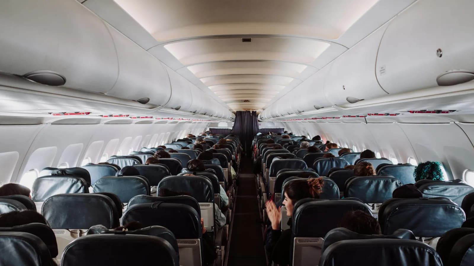 Passengers seated inside a commercial airplane cabin during flight.