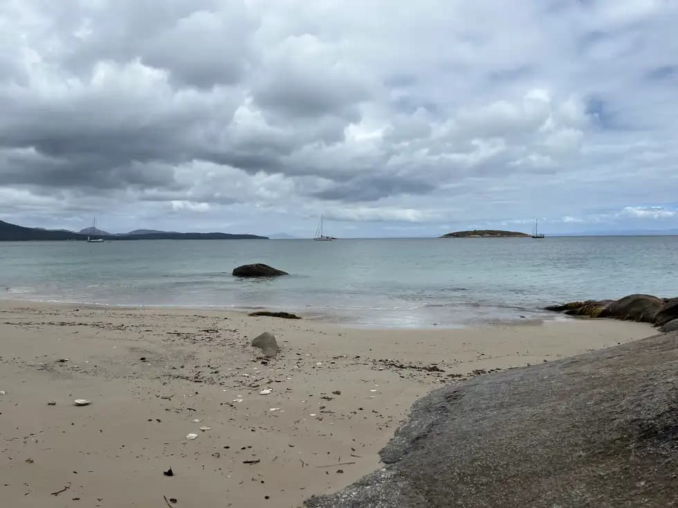 Great Oyster Bay calm waters with moored sailboats and distant island