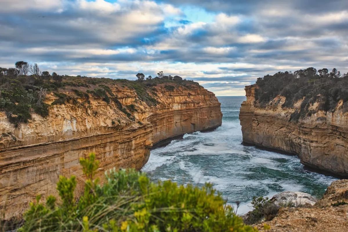 The entrance to Loch Ard Gorge between towering limestone walls with dramatic clouds