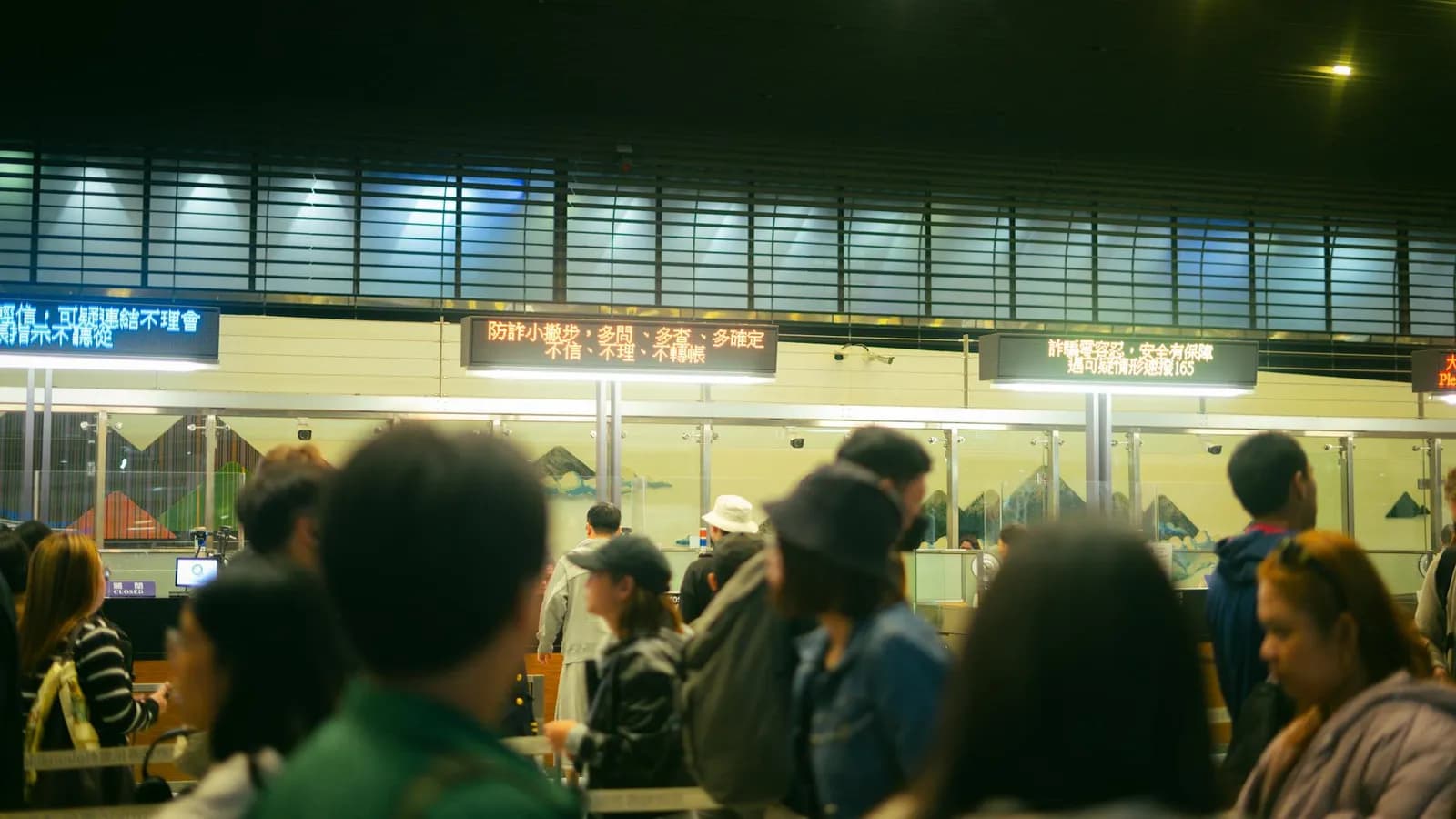 Travellers queuing patiently at an airport check-in counter.