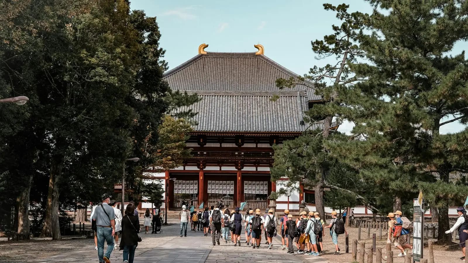 Visitors walking respectfully towards Tōdai-ji Temple in Nara, Japan.